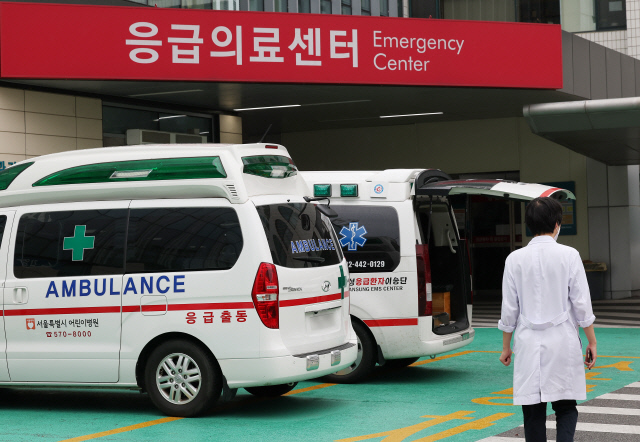 추석 연휴를 앞두고 응급실 과부하에 대한 우려가 커지고 있는 가운데 2일 서울 한 대형병원 응급의료센터 인근에서 한 의료 관계자가 구급차 인근을 지나치고 있다. <연합뉴스>